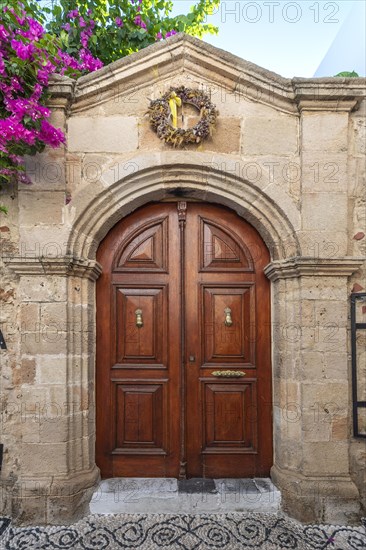 Old wooden door with pebble mosaics on the floor