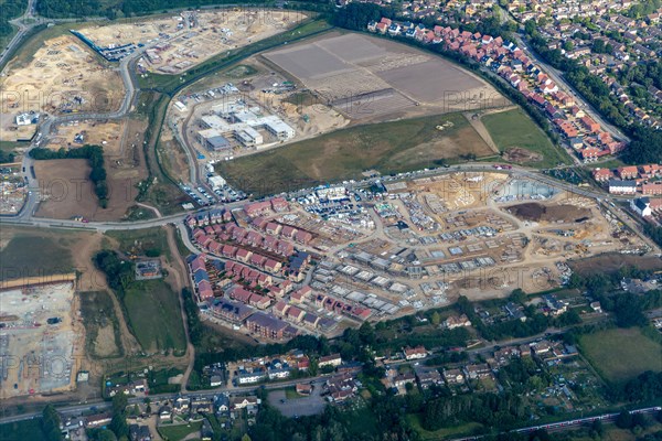 Oblique aerial view through plane window of construction of new housing estate in Bishop's Stortford town