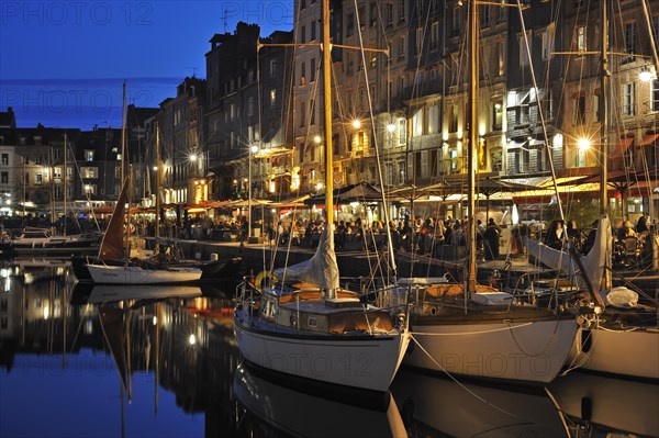 Sailing boats and tourists at pavement cafes