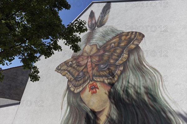 Portrait of a woman with pointed lips and butterfly in front of her face