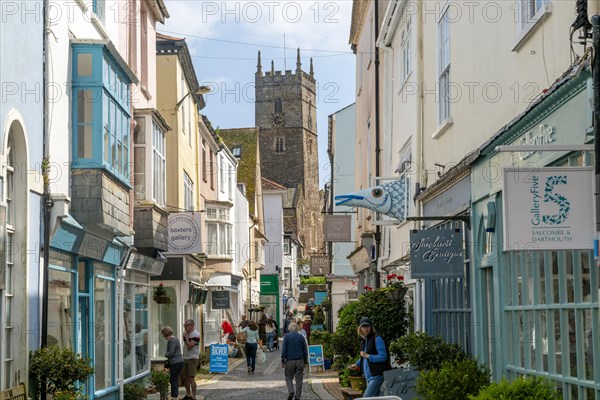 Shops in historic buildings along alleyway with tower of church of St Saviour