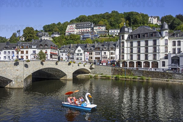 Paddle boat with tourists passing under the bridge Pont de Liege in the city Bouillon in summer