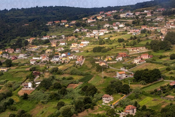 View through plane window of rural landscape and settlement of Negros approaching airport at Vigo