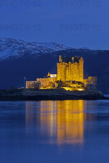 Illuminated Eilean Donan Castle in Loch Duich in winter at dusk