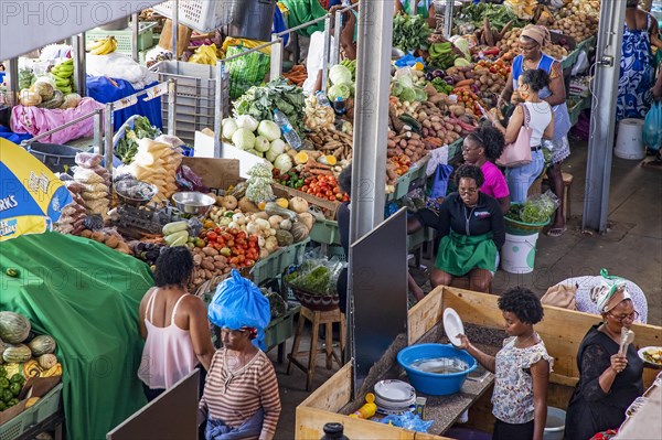 Stalls with fresh fruit and vegetables for sale at busy indoor food market in the city Praia on the island Santiago