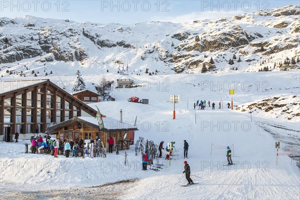Skiers and snowboarders at apres-ski bar in Swiss ski resort in the Alps in winter