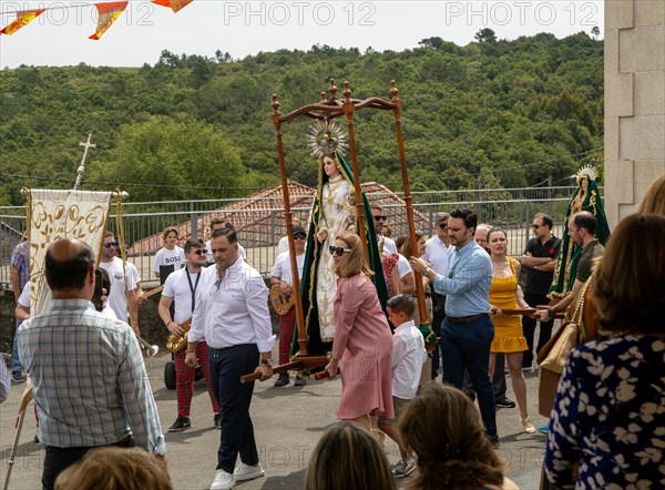 Village fiesta procession of villagers with statue of Virgin Mary