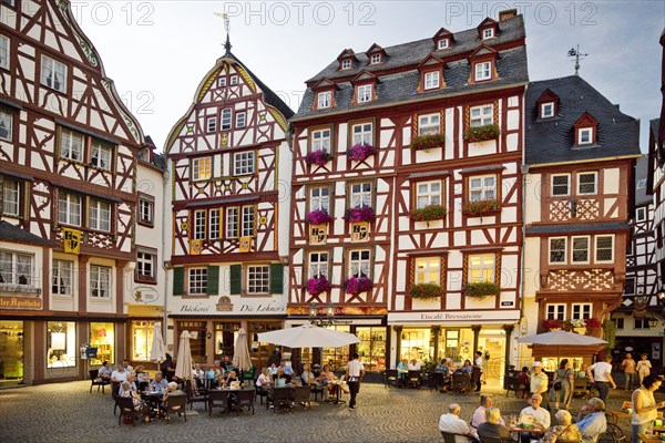 Gabled half-timbered houses on the busy medieval market square in the evening