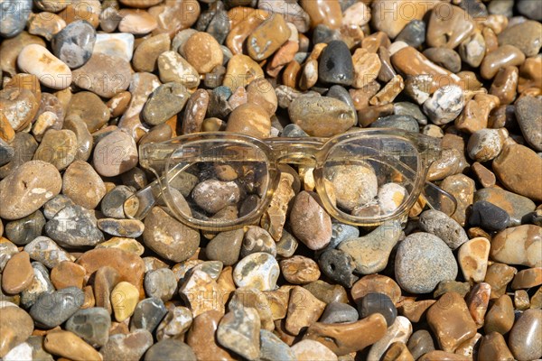 Pair of plastic spectacles glasses washed up on shingle beach