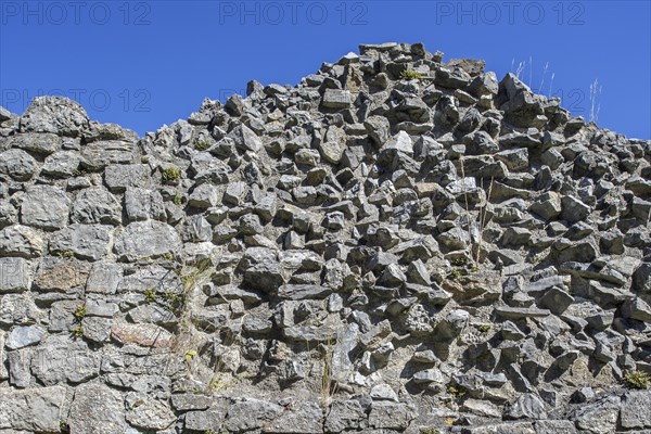 Thick stone wall of medieval castle showing two types of masonry