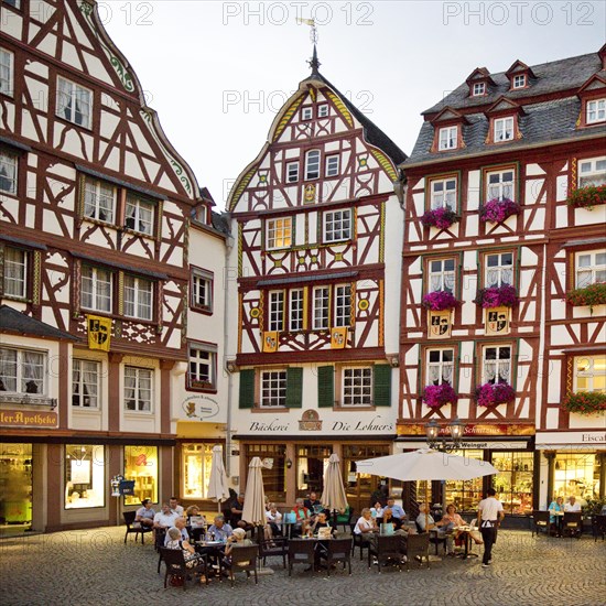 Gabled half-timbered houses on the busy medieval market square in the evening