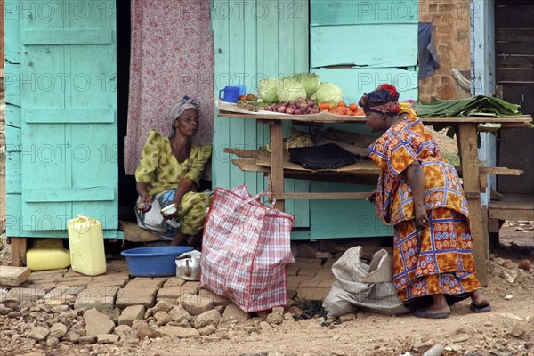 Black woman buying vegetables from street vendor in the city Kampala