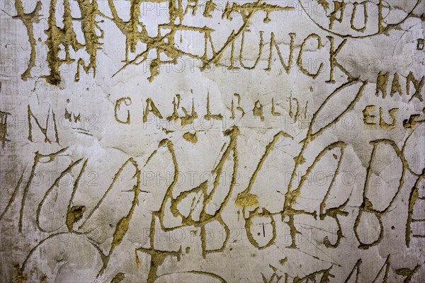Old graffiti and scratchwork on wall inside the medieval Chateau de Bouillon Castle