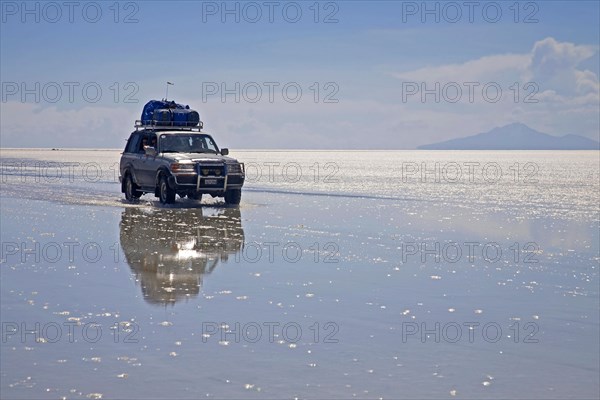 Four-wheel drive vehicle driving on the salt flat Salar de Uyuni