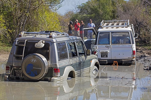 Four-wheel drive vehicle pulling off-road car out of mud on the dirt road from Morondava to Toliara