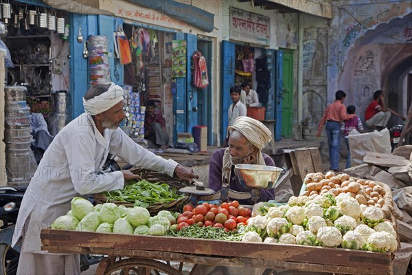 Vendors selling vegetables on wooden cart at market in Barsana