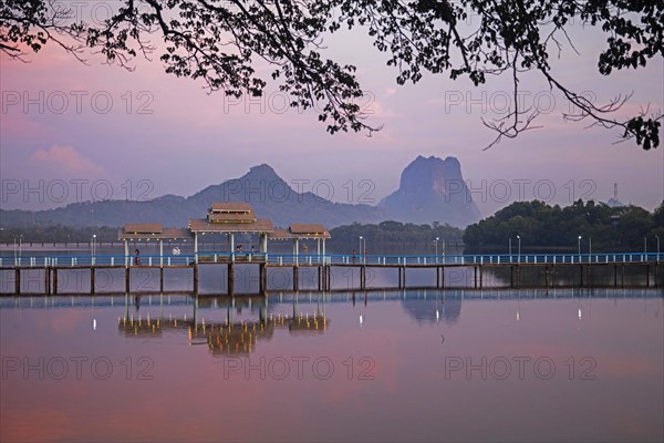 Wooden bridge over Kan Thar Yar Lake at sunset