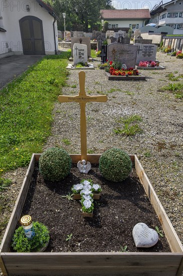 Cemetery and simple grave with praying angel