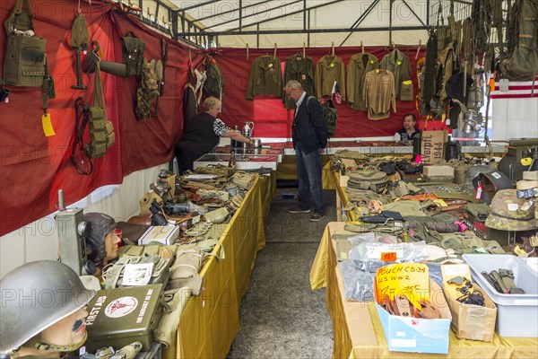 Vendor in WWII stand selling military artifacts to World War Two collector at WW2 militaria fair