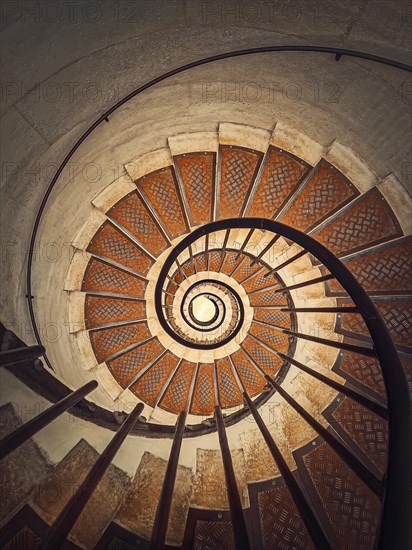 Circular staircase with black metal railing