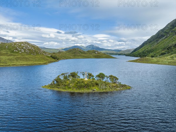 Aerial view of a small island with a Celtic stone cross in the freshwater loch of Loch Stack in the Northern Highlands