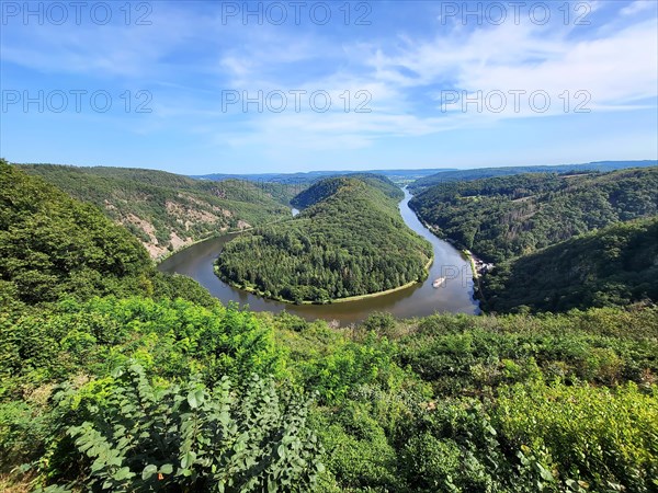 Aerial view of the Saar Loop. The Saar winds through the valley and is surrounded by green forests. Orscholz