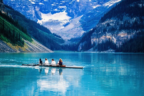 Four women paddling a kayak in a beautiful mountain lake