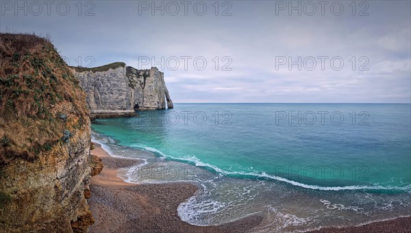 Sightseeing view to the wonderful cliffs of Etretat washed by the waves of the blue sea water