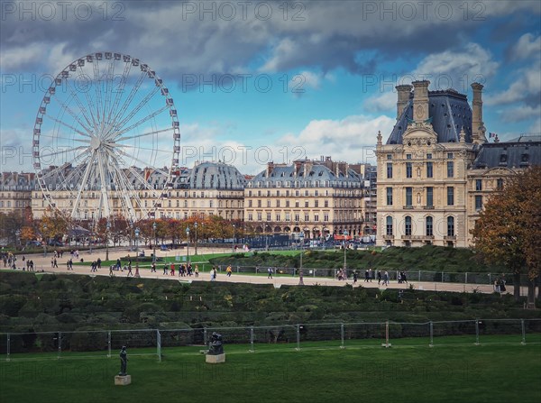 Cityscape view to the Grande Roue de Paris ferris wheel next to Louvre museum building and parisian houses