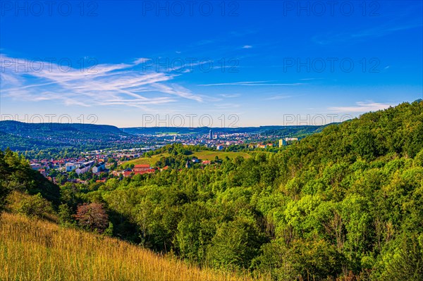 View over the city of Jena from the Galgenberg with the Kernberge in the background under blue sky and veil clouds