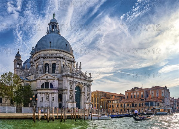 Beautiful view of iconic basilica di Santa Maria della Salute or St Mary of Health and colorful palaces or palazzo by waterfront of Grand Canal