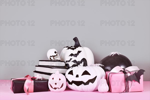 Pink and white Halloween decor with black and white pumpkins