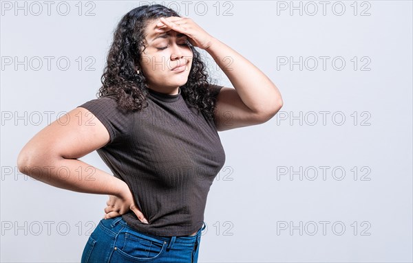 Tired woman holding his head isolated.. Worried young woman holding his forehead. Worried girl isolated