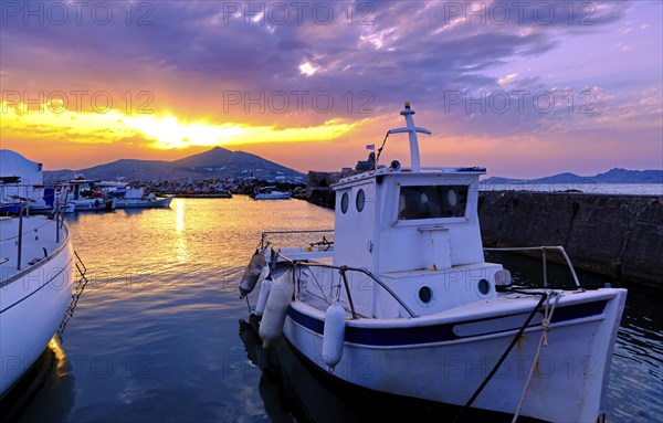 Colorful sunset over quiet Greek fishing village and its harbour