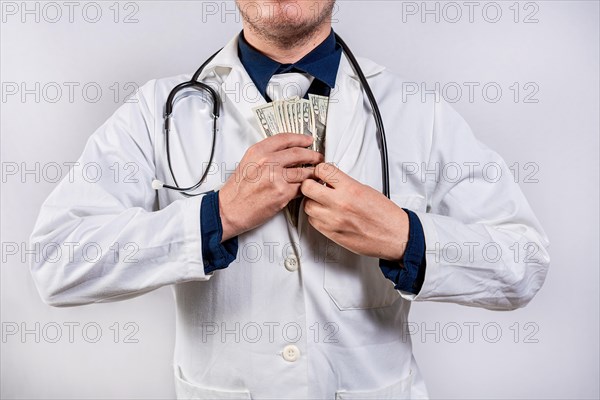 Dishonest doctor putting money in pocket. Medical bribery concept