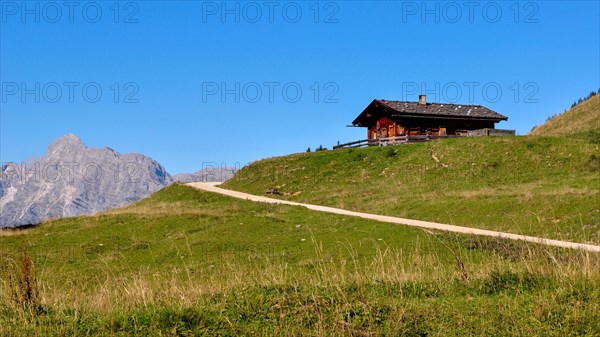 One of the rustic alpine huts on the Kallbrunnalm in the Berchtesgaden Alps with the Loferer Steinberge in the background