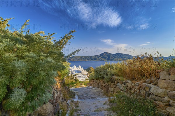 Beautiful view of typical Greek village by seafront in evening. Whitewashed houses