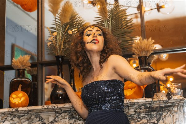 Portrait of a woman singing in costume and makeup at the halloween party in a disco nightclub