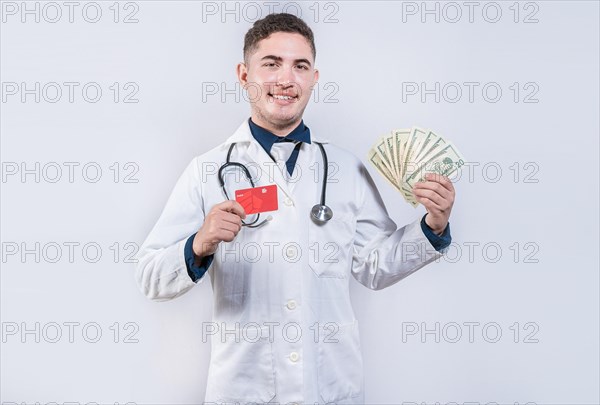 Happy latin doctor holding credit card and money isolated. Cheerful doctor holding money and credit cards