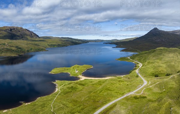 Aerial panorama of the freshwater loch Loch Assynt with the ruins of Ardvreck Castle on a peninsula