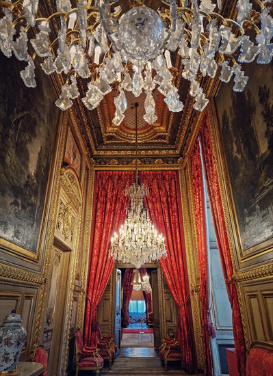 Beautiful decorated Napoleon apartments at Louvre palace. Royal family rooms with cardinal red curtains