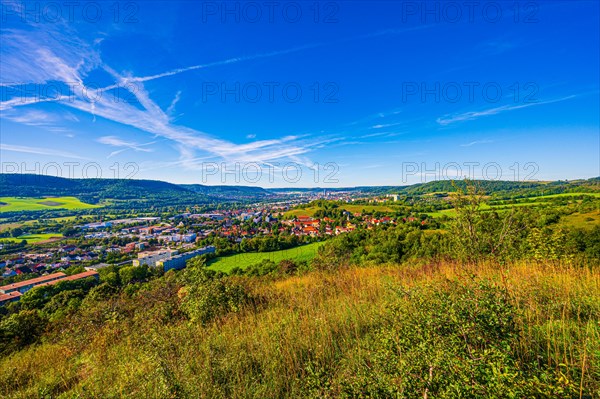 View over the city of Jena from the Galgenberg with the Kernberge in the background under blue sky and veil clouds