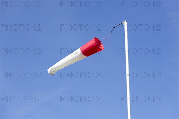 White-red windsock against blue sky