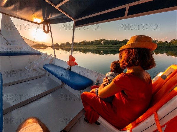 Mother with her son on a boat on a tourist excursion on Lake Shkoder in Shiroka. Albania