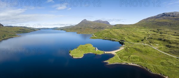 Aerial panorama of the freshwater loch Loch Assynt with the ruins of Ardvreck Castle on a peninsula