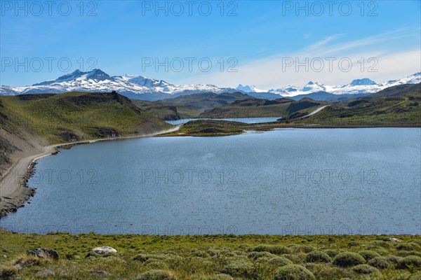 Gravel road in Torres del Paine National Park with snow-capped mountains