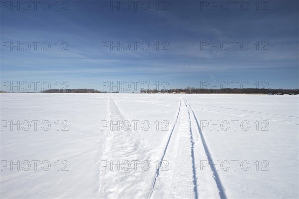 Vehicle tracks on snow covered frozen river