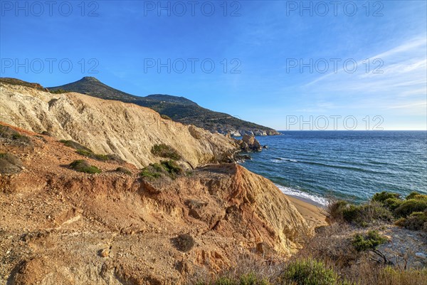 Beautiful sunset view of secluded and remote beach on sunny evening. High yellow cliffs