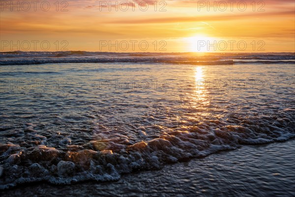 Atlantic ocean sunset with surging waves at Fonte da Telha beach