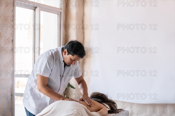 Professional male masseuse and his patient in a spa